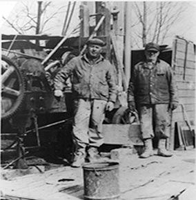 Black and white photo of Max Larson and Malcolm Larson against a cable tool drilling rig 